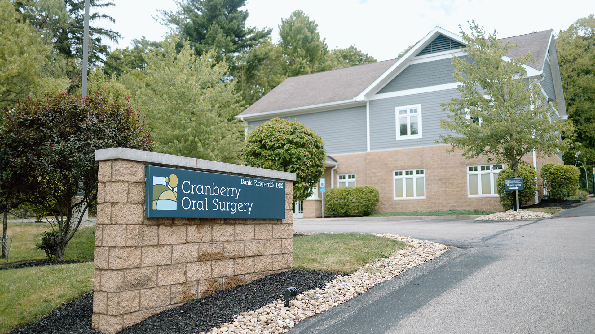 The image shows a sign for Cramer Dental Clinic in front of a building with a sign that reads Cramer Dental Clinic and a brick entrance.